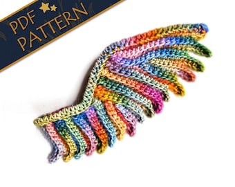 May include: A colorful crocheted wing with a rainbow of colors, including pink, blue, green, yellow, and orange. The wing is made with a textured stitch and has a slightly curved shape.