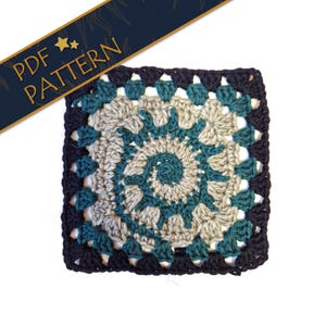 Puede incluir: Un cuadrado de ganchillo con un borde negro y un centro de color verde azulado y beige. El centro tiene un diseño en espiral.