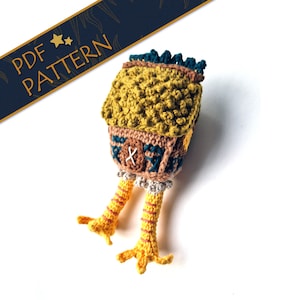 May include: Crocheted amigurumi toy in the shape of a house with legs. The house is brown with a yellow roof and green trim. The legs are yellow and white.