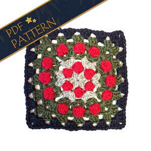 May include: A square, crocheted granny square with a floral design. The square features a dark navy blue border, green and gray leaves, and red flower-like accents. The text "PDF PATTERN" is displayed on a navy blue banner.