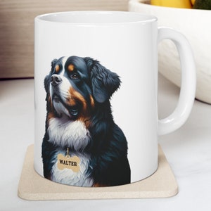 May include: White ceramic mug featuring a detailed illustration of a Bernese Mountain Dog with the name "WALTER" on a tag. The dog has black, brown, and white fur. The mug sits on a beige coaster.