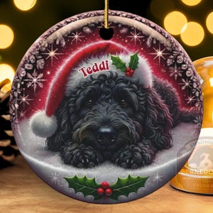 Black bernedoodle or labradoodle dog ceramic ornament show hanging with a gold string.  The ornament measures 3 inches in diameter and is a full gloss, printed on both sides.