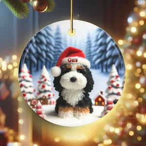 Bernedoodle claymation style ornament made of ceramic, hanging by a gold string.  Winter scene featuring a cute, personalized doodle dog with personalized name on santa hat.  Perfect gift for Bernedoodle Dog Lovers and Pet Enthusiasts.