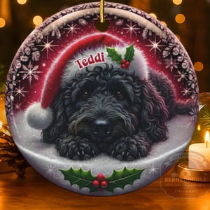 Black bernedoodle or labradoodle dog ceramic ornament show hanging with a gold string.  The ornament measures 3 inches in diameter and is a full gloss, printed on both sides.