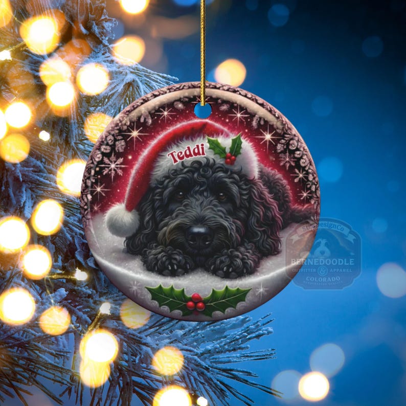 Black bernedoodle or labradoodle dog ceramic ornament show hanging with a gold string.  The ornament measures 3 inches in diameter and is a full gloss, printed on both sides.