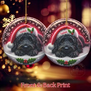 May include: Two round Christmas ornaments featuring a black dog wearing a Santa hat with the name "Teddi". The ornaments have a snowy background with holly and snowflake details. The text "Front & Back Print" is at the bottom.