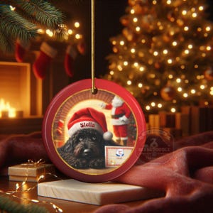 This ceramic ornament features a cute black goldendoodle (or Labradoodle)...Or black bernedoodle dog wearing a Santa hat and being on their best behavior for Santa, surrounded by holiday decorations.  Three inch ceramic dog ornament with a black bernedoodle black golden doodle black goldendoodle dog wearing a santa hat on this cute dog ornament gift.  Perfect ornament for a dog person, dog lover, doodle mom or doodle dad.