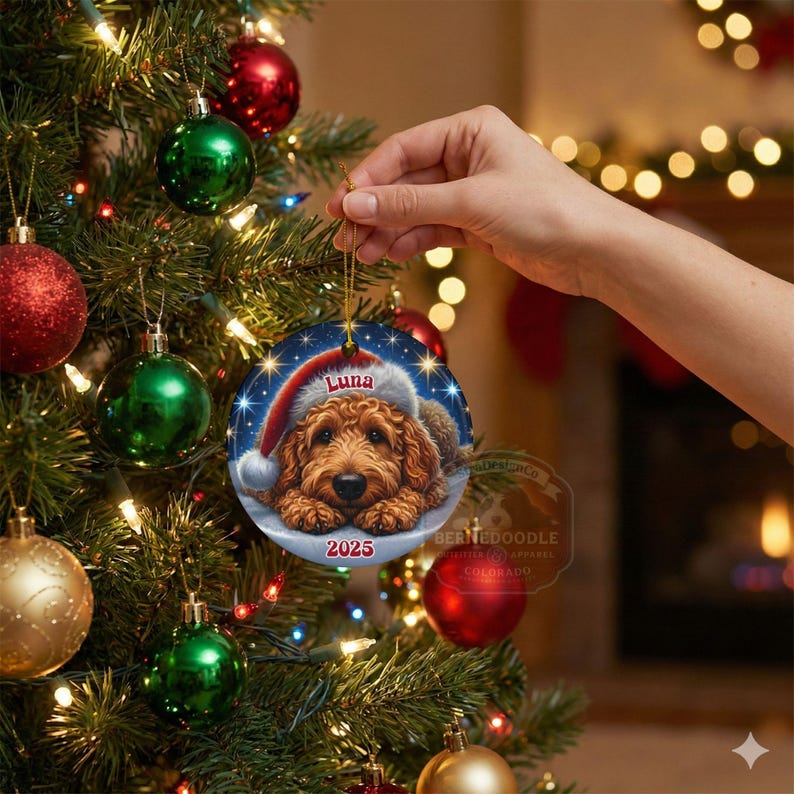 A ceramic ornament of a goldendoodle dog wearing a Santa hat, personalized with the dog's name and the year.  Gorgeously placed in a warm background with candles and Christmas lights.