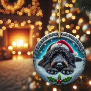Black goldendoodle ceramic ornament with two sided design.  Black golden doodle , black bernedoodle dog decor.  The picture is showing the ornaments printed on each side.  Gorgeous blue ornament with black doodle dog wearing a santa hat.  Personalized with dog's name.