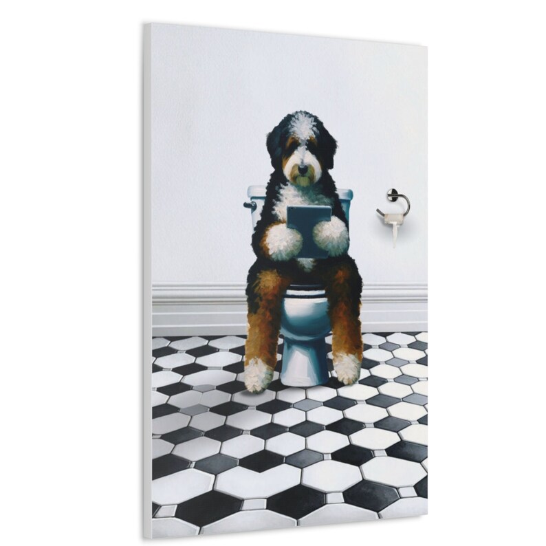 May include: A canvas print featuring a Bernese Mountain Dog sitting on a white toilet, holding a tablet. The dog has black, brown, and white fur. The bathroom has a black and white hexagonal tile floor and a silver toilet paper holder on the wall.