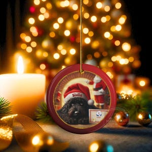 This ceramic ornament features a cute black goldendoodle (or Labradoodle)...Or black bernedoodle dog wearing a Santa hat and being on their best behavior for Santa, surrounded by holiday decorations.  Three inch ceramic dog ornament with a black bernedoodle black golden doodle black goldendoodle dog wearing a santa hat on this cute dog ornament gift.  Perfect ornament for a dog person, dog lover, doodle mom or doodle dad.