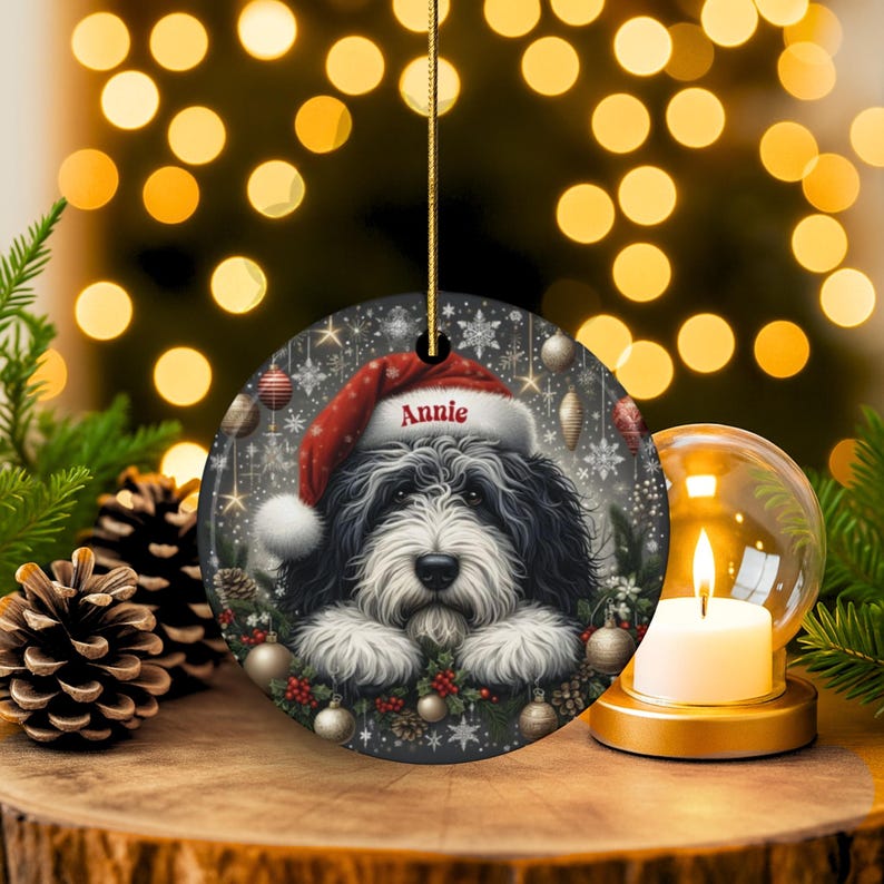 Sheepadoodle custom ornament on display with glowing lights in the background.  This 3 inch ceramic ornament is perfect for Sheepa Doodle lovers everywhere.