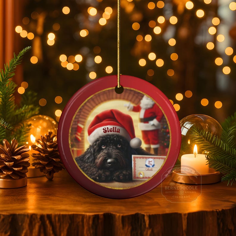 This ceramic ornament features a cute black goldendoodle (or Labradoodle)...Or black bernedoodle dog wearing a Santa hat and being on their best behavior for Santa, surrounded by holiday decorations.  Three inch ceramic dog ornament with a black bernedoodle black golden doodle black goldendoodle dog wearing a santa hat on this cute dog ornament gift.  Perfect ornament for a dog person, dog lover, doodle mom or doodle dad.