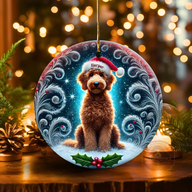 Round ceramic Christmas ornament featuring a cute curly goldendoodle wearing a Santa hat with festive holly and winter swirls.