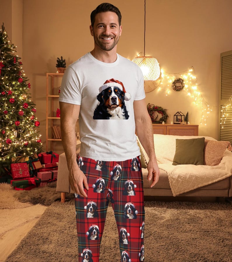 A man seen wearing Men's pajama pants lounge wear personalized Christmas pajama bottoms with Bernese Mountain dogs wearing Santa Hat and their name is on the Santa Hat.  Bernese Mountain Dog dad gear!