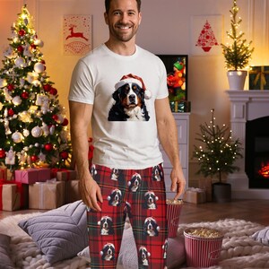 A man seen wearing Men's pajama pants lounge wear personalized Christmas pajama bottoms with Bernese Mountain dogs wearing Santa Hat and their name is on the Santa Hat.  Bernese Mountain Dog dad gear!