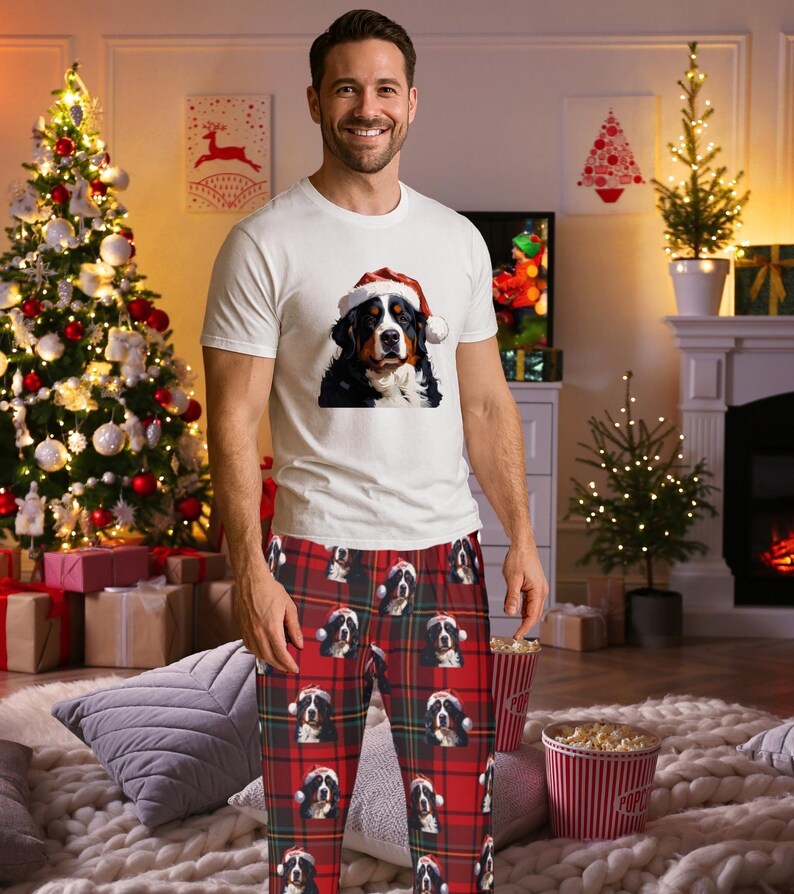 A man seen wearing Men's pajama pants lounge wear personalized Christmas pajama bottoms with Bernese Mountain dogs wearing Santa Hat and their name is on the Santa Hat.  Bernese Mountain Dog dad gear!