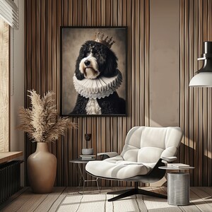 May include: A framed portrait of a black and white dog wearing a gold crown and a ruffled collar. The dog is the focal point, set against a neutral background. The room features a modern white chair, a side table, and a tall vase with dried plants.