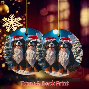 Op de afbeelding: Twee ronde kerstversieringen met Berner Sennenhonden met kerstmutsen. Elke hond heeft een naam op zijn muts. De ornamenten hangen aan gouden touwtjes. De tekst "Front & Back Print" staat onderaan.