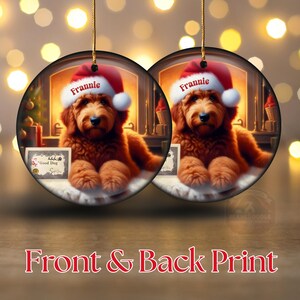 Pu&ograve; includere: Due decorazioni natalizie rotonde con un cane marrone con un cappello da Babbo Natale con il nome "Frannie". Il cane &egrave; di fronte a una scena di camino. Un ornamento ha un piccolo cartello con la scritta "Good Dog". Il testo "Front & Back Print" &egrave; in basso.