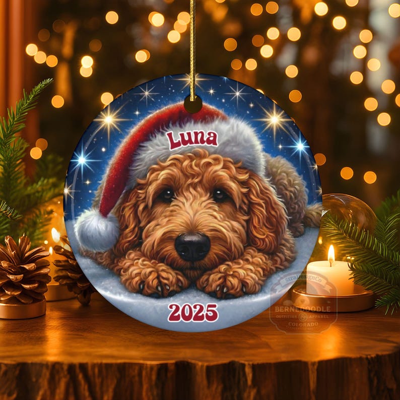A ceramic ornament of a goldendoodle dog wearing a Santa hat, personalized with the dog's name and the year.  Gorgeously placed in a warm background with candles and Christmas lights.