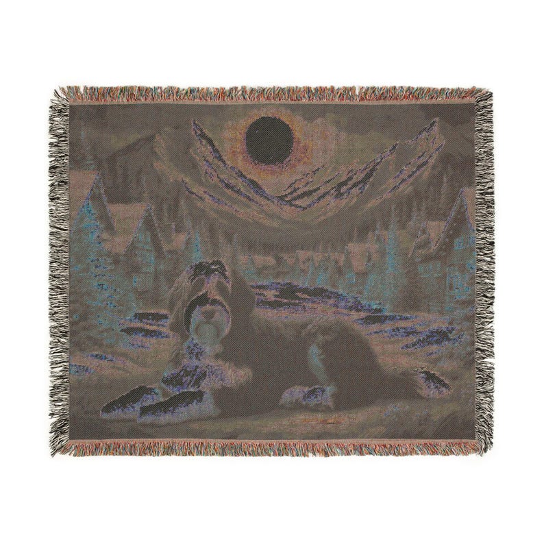 May include: Woven throw blanket featuring a dog lying down in a landscape with mountains, trees, and a dark sun. The color palette includes shades of brown, blue, and purple. The blanket has a fringed edge.