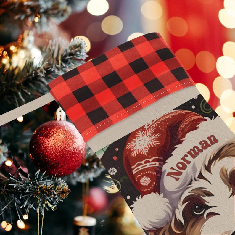 A festive Christmas stocking featuring a whimsical illustrated doodle dog wearing a red Santa hat, surrounded by holiday ornaments and greenery in a warm, detailed Christmas art style. The top of the stocking has a classic red and black buffalo-plaid cuff, and the stocking hangs from a white mantel decorated with evergreen garland and gold ornaments. The stocking design is personalized with your dog’s name, making it a charming and custom holiday décor piece for dog lovers.