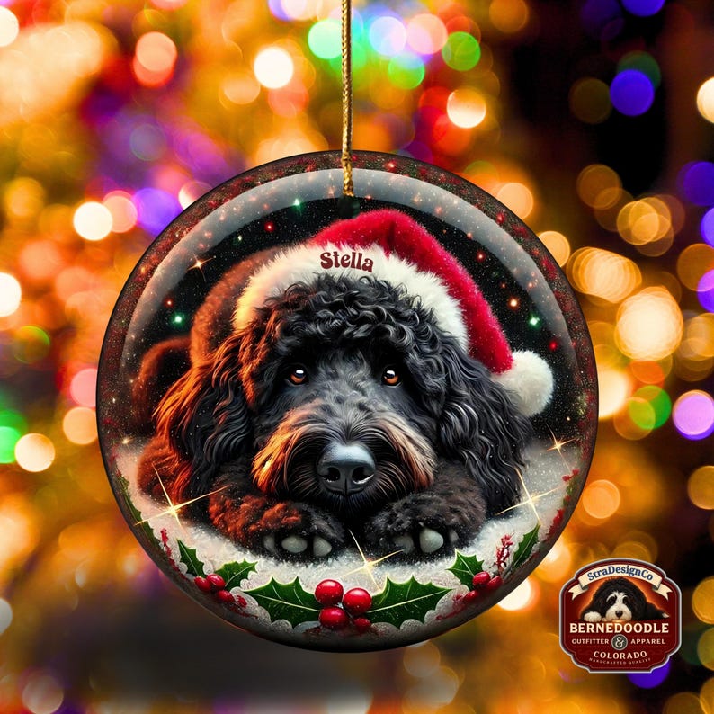 Black bernedoodle or labradoodle dog ceramic ornament show hanging with a gold string.  The ornament measures 3 inches in diameter and is a full gloss, printed on both sides.