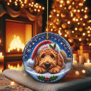 Golden Doodle dog ceramic ornament show hanging with a gold string.  The Goldendoodle Dog ornament measures 3 inches in diameter and is a full gloss, printed on both sides.