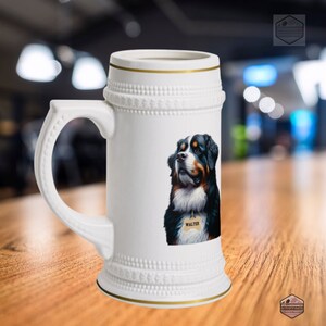 May include: White ceramic beer stein with a gold rim and handle. The stein features a detailed illustration of a Bernese Mountain Dog with a tag that says "Walter". The stein has a decorative embossed design around the top and bottom.