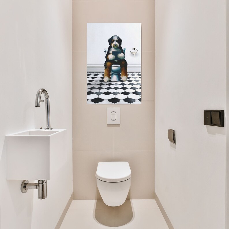 May include: A rectangular wall art print featuring a black, white, and brown Bernese Mountain Dog sitting on a white toilet while reading a book. The background of the artwork shows a black and white hexagonal tiled floor and a white wall.