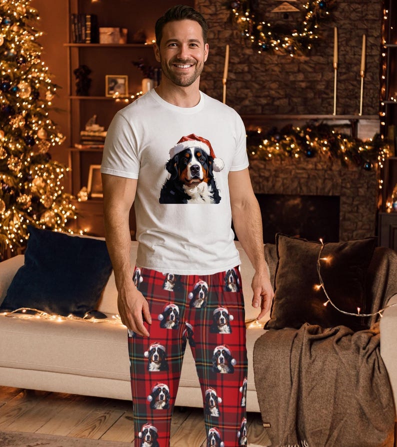 A man seen wearing Men's pajama pants lounge wear personalized Christmas pajama bottoms with Bernese Mountain dogs wearing Santa Hat and their name is on the Santa Hat.  Bernese Mountain Dog dad gear!