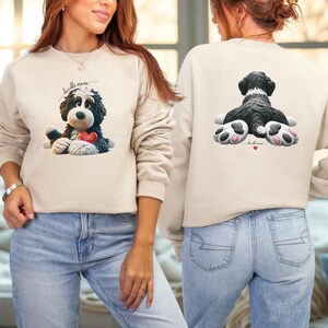 K&ouml;nnte beinhalten: Beiges Sweatshirt mit einem schwarz-wei&szlig;en Doodle-Hunde-Motiv und einem roten herzf&ouml;rmigen Anh&auml;nger mit der Aufschrift "Beattie". Auf der Vorderseite steht in Schreibschrift "doodle mom". Auf der R&uuml;ckseite ist das Hinterteil des Hundes zu sehen.
