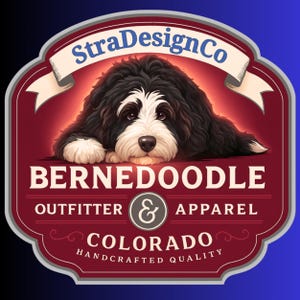 Op de afbeelding: Een logo met een Bernedoodle-hond met zwart, wit en bruin haar, rustend op een rode en kastanjebruine achtergrond. De tekst luidt "StraDesignCo", "BERNEDOODLE OUTFITTER & APPAREL" en "COLORADO HANDCRAFTED QUALITY".