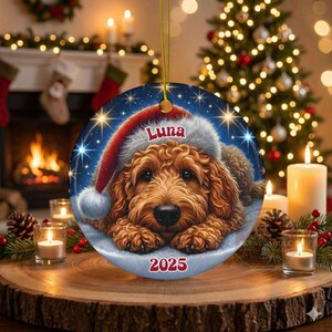 A ceramic ornament of a goldendoodle dog wearing a Santa hat, personalized with the dog's name and the year.  Gorgeously placed in a warm background with candles and Christmas lights.