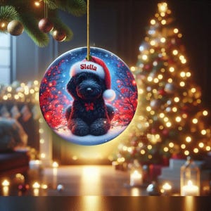 Capture the magic of the season with this adorable black Goldendoodle puppy wearing a festive Santa hat, surrounded by glowing red berries and twinkling snowflakes! Perfect personalized Christmas tree ornament for doodle parents. Add your dog's name (like "Stella") for a heartfelt touch. High-quality ceramic, vibrant print, gold string included. Ideal dog mom/dad gift, stocking stuffer, or memorial keepsake. Handmade holiday charm!