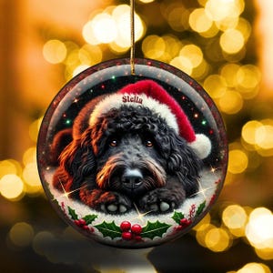 Black bernedoodle or labradoodle dog ceramic ornament show hanging with a gold string.  The ornament measures 3 inches in diameter and is a full gloss, printed on both sides.