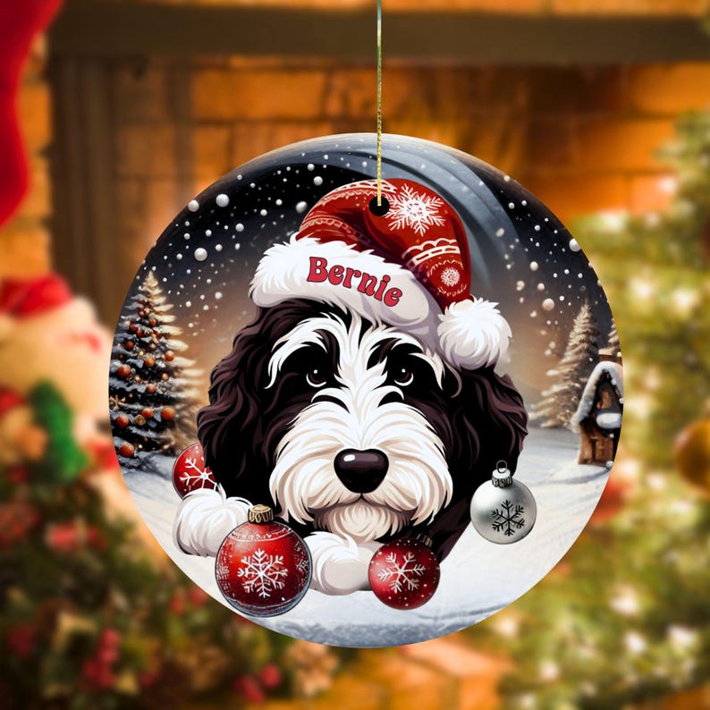 Personalize your holiday decor with this charming Bernedoodle Christmas ornament! Featuring a cute Bernedoodle in a festive Santa hat and customizable name, this round ornament adds warmth and joy to any tree. Perfect for dog lovers and unique gifts!