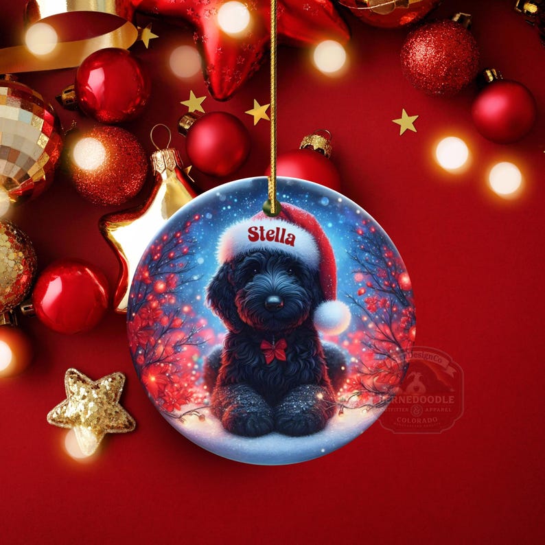 Capture the magic of the season with this adorable black Goldendoodle puppy wearing a festive Santa hat, surrounded by glowing red berries and twinkling snowflakes! Perfect personalized Christmas tree ornament for doodle parents. Add your dog's name (like "Stella") for a heartfelt touch. High-quality ceramic, vibrant print, gold string included. Ideal dog mom/dad gift, stocking stuffer, or memorial keepsake. Handmade holiday charm!
