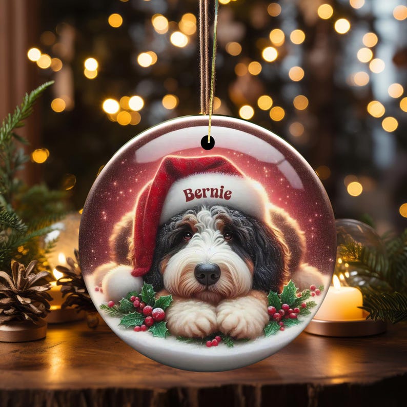 Personalize your holiday decor with this charming Bernedoodle Christmas ornament! Featuring a cute Bernedoodle in a festive Santa hat and customizable name, this round ornament adds warmth and joy to any tree. Perfect for dog lovers and unique gifts!
