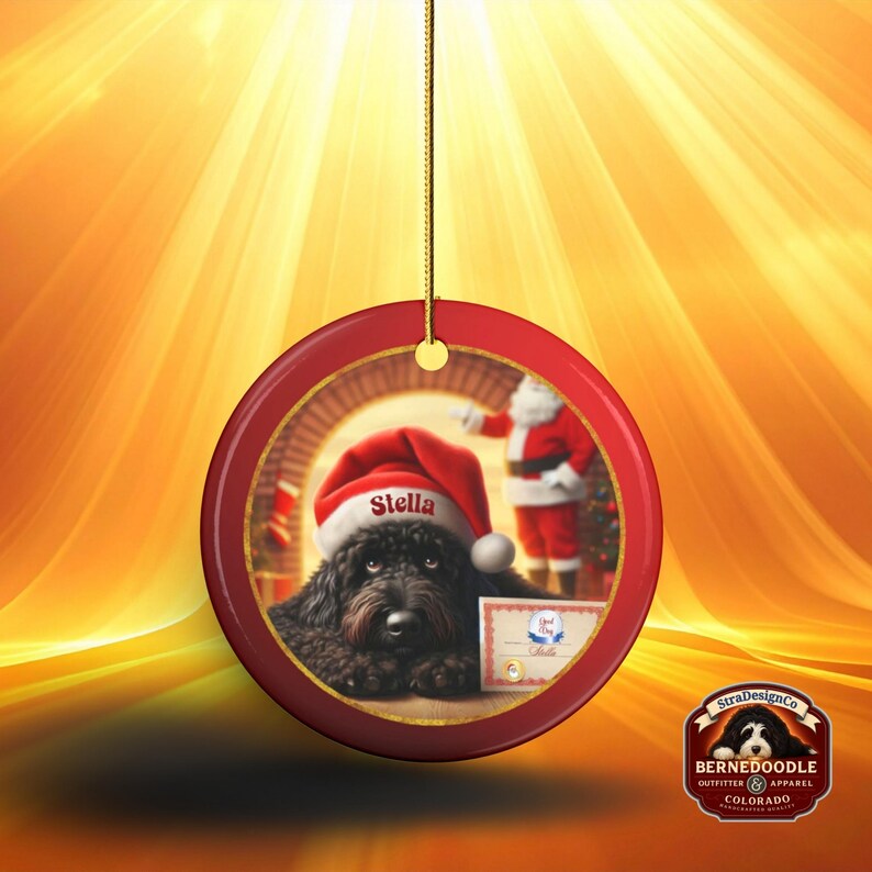 This ceramic ornament features a cute black goldendoodle (or Labradoodle)...Or black bernedoodle dog wearing a Santa hat and being on their best behavior for Santa, surrounded by holiday decorations.  Three inch ceramic dog ornament with a black bernedoodle black golden doodle black goldendoodle dog wearing a santa hat on this cute dog ornament gift.  Perfect ornament for a dog person, dog lover, doodle mom or doodle dad.