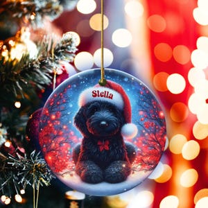 Capture the magic of the season with this adorable black Goldendoodle puppy wearing a festive Santa hat, surrounded by glowing red berries and twinkling snowflakes! Perfect personalized Christmas tree ornament for doodle parents. Add your dog's name (like "Stella") for a heartfelt touch. High-quality ceramic, vibrant print, gold string included. Ideal dog mom/dad gift, stocking stuffer, or memorial keepsake. Handmade holiday charm!