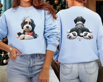 Może przedstawiać: Jasnoniebieska bluza z nadrukiem czarno-białego psa z czerwonym sercem z napisem "BAMBIE". Przód bluzy ma napis "doodle mom". Tył bluzy ma grafikę z tyłu psa.