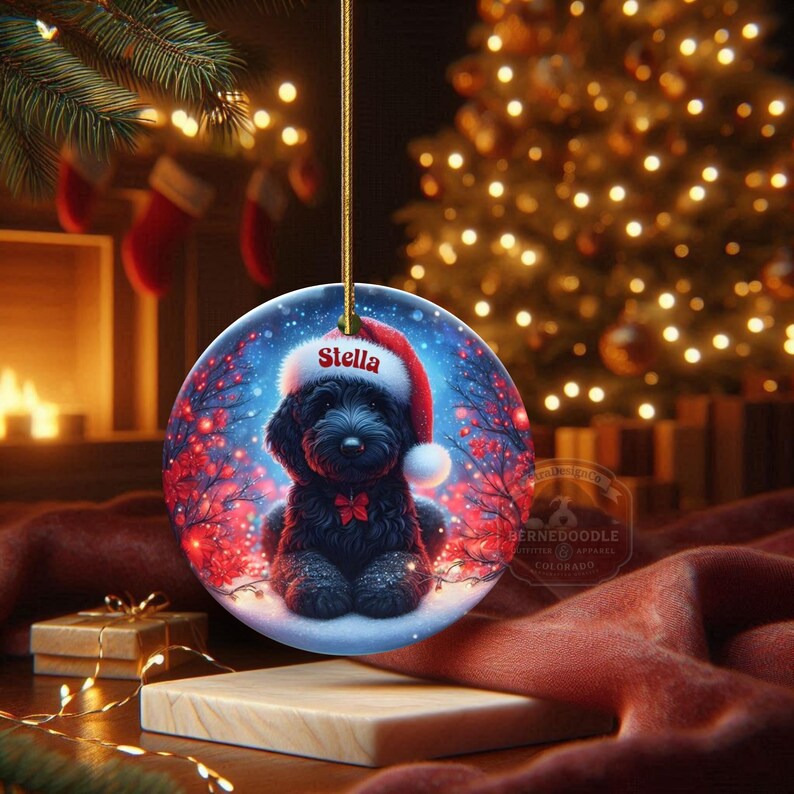 Capture the magic of the season with this adorable black Goldendoodle puppy wearing a festive Santa hat, surrounded by glowing red berries and twinkling snowflakes! Perfect personalized Christmas tree ornament for doodle parents. Add your dog's name (like "Stella") for a heartfelt touch. High-quality ceramic, vibrant print, gold string included. Ideal dog mom/dad gift, stocking stuffer, or memorial keepsake. Handmade holiday charm!