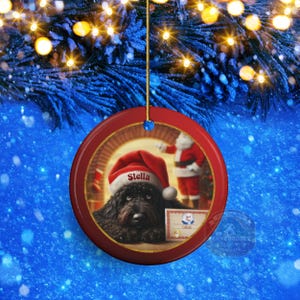This ceramic ornament features a cute black goldendoodle (or Labradoodle)...Or black bernedoodle dog wearing a Santa hat and being on their best behavior for Santa, surrounded by holiday decorations.  Three inch ceramic dog ornament with a black bernedoodle black golden doodle black goldendoodle dog wearing a santa hat on this cute dog ornament gift.  Perfect ornament for a dog person, dog lover, doodle mom or doodle dad.