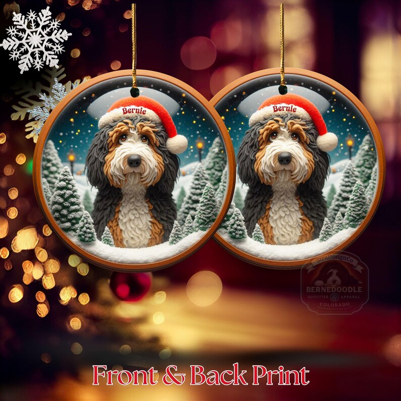 Op de afbeelding: Twee ronde kerstversieringen met een Bernedoodle-hond met een kerstmuts met de naam "Bernie". De ornamenten hebben een winterse achtergrond met besneeuwde bomen. De tekst "Front & Back Print" staat onderaan.
