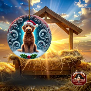 Round ceramic Christmas ornament featuring a fluffy brown goldendoodle sitting in snowy glitter. The dog wears a red Santa hat with white trim and the name “Harper.” Swirling icy feather details, blue starry background, and holly berries add a festive holiday feel. Warm lights glow behind it, making it a cozy décor piece for pet lovers and doodle families.