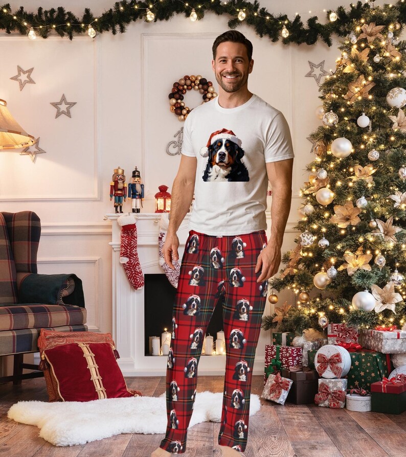 A man seen wearing Men's pajama pants lounge wear personalized Christmas pajama bottoms with Bernese Mountain dogs wearing Santa Hat and their name is on the Santa Hat.  Bernese Mountain Dog dad gear!