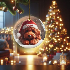 This ceramic ornament features a cute red mini-doodle golden doodle or goldendoodle dog wearing a Santa hat in a snow globe setting, surrounded by holiday decorations. Perfect for adding a festive touch to your Christmas tree or as a thoughtful gift for dog lovers.