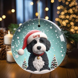 Celebrate the holidays with this adorable Bernedoodle Christmas ornament! Featuring a charming claymation-style Bernie in a Santa hat, surrounded by snowflakes and festive trees, this ornament adds warmth and joy to any holiday decor. For dog lovers!